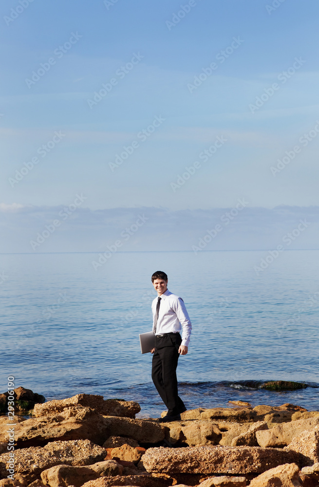 Man near sea with laptop
