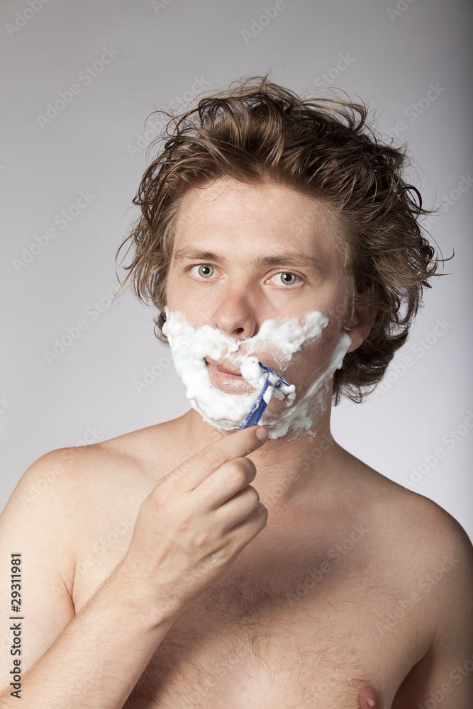 Attractive young man shaving