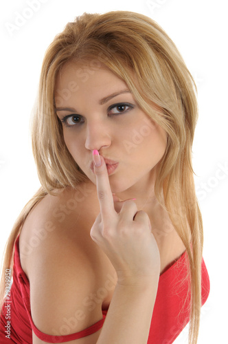 Young woman holds finger at mouth