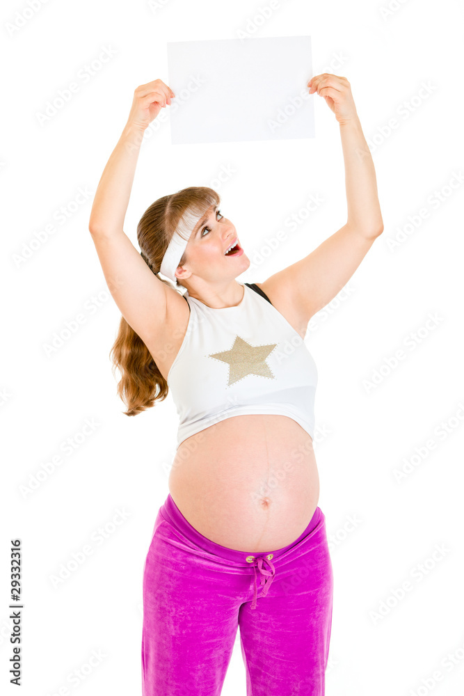 Surprised pregnant woman holding empty paper over her head Surprised pregnant woman holding empty paper over her head