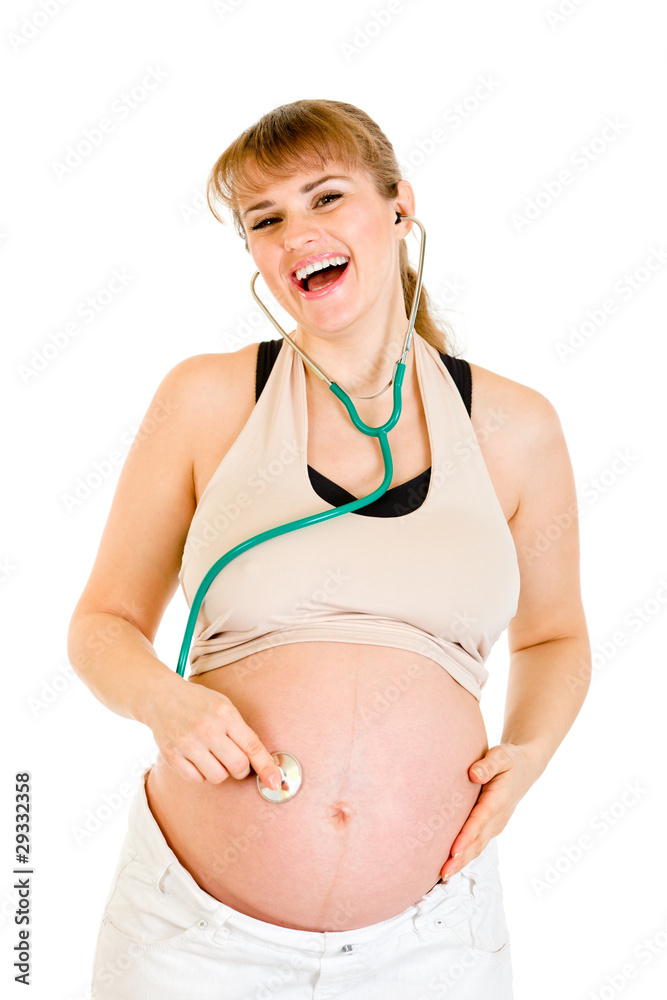 Laughing pregnant woman holding stethascope on her belly Laughing pregnant woman holding stethascope on her belly