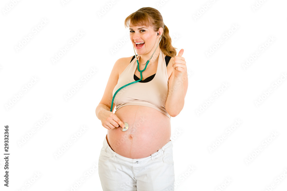Happy pregnant woman with stethascope showing thumbs up gesture Happy pregnant woman with stethascope showing thumbs up gesture