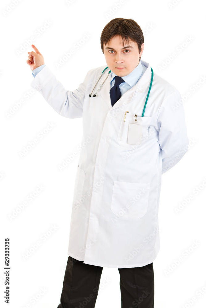 Serious medical doctor pointing finger in corner isolated Serious medical doctor pointing finger in corner isolated