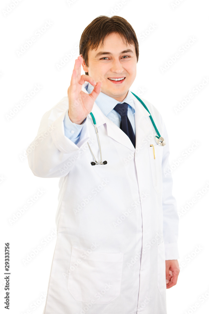 Smiling medical doctor showing ok gesture isolated on white. Smiling medical doctor showing ok gesture isolated on white.
