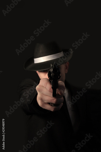 elegant gangster dressed in a black suit with gun