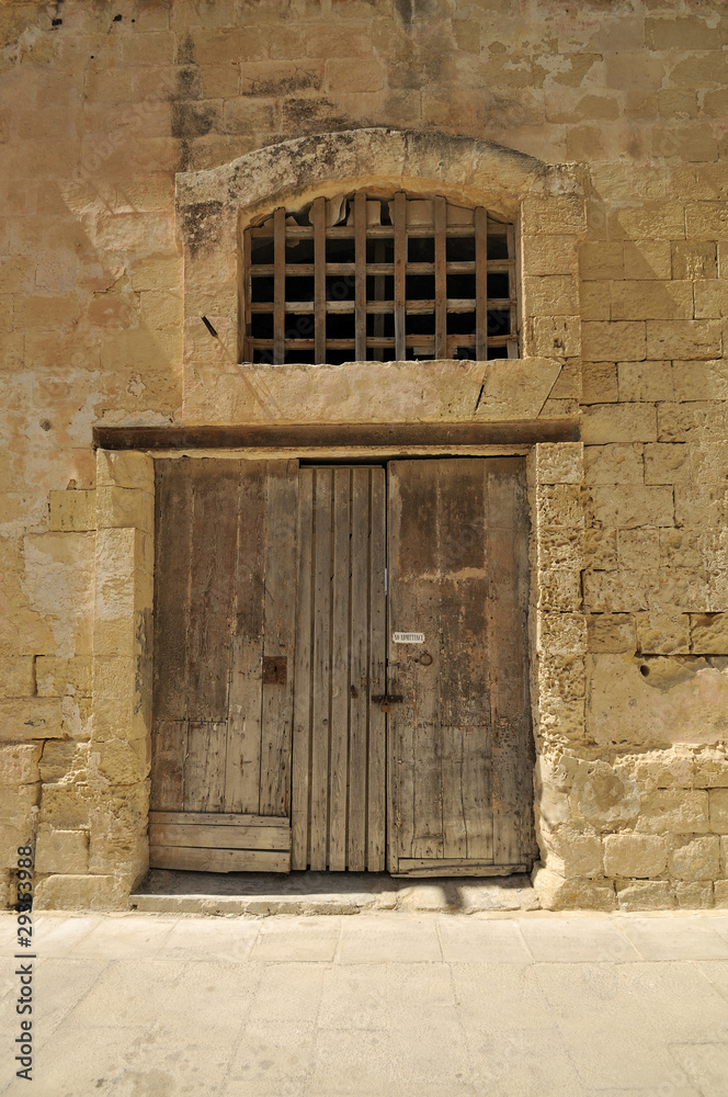 Old wooden door in a stone wall Old wooden door in a stone wall