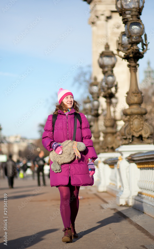 Happy tourist girl with funny bag in Paris on the Pont Alexandre