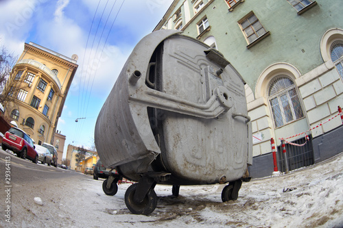 Old rusty trash can in a dirty city street