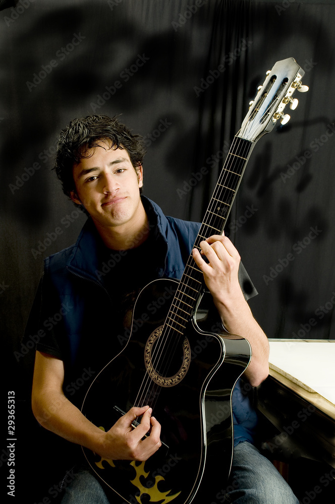 Joven tocando guitarra en fondo negro Young person touching Stock