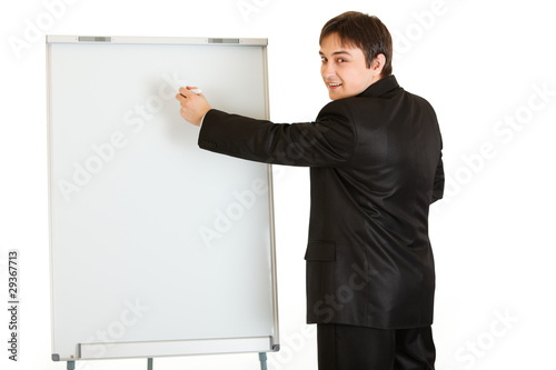 Smiling modern businessman giving presentation using flipchart