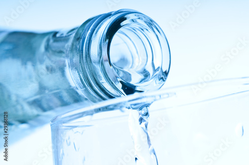 bottle pouring water into glass