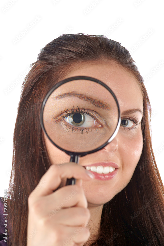 Smiling girl looking through magnifying glass Smiling girl looking through magnifying glass