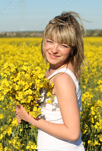 young beautiful woman on blooming field in summer