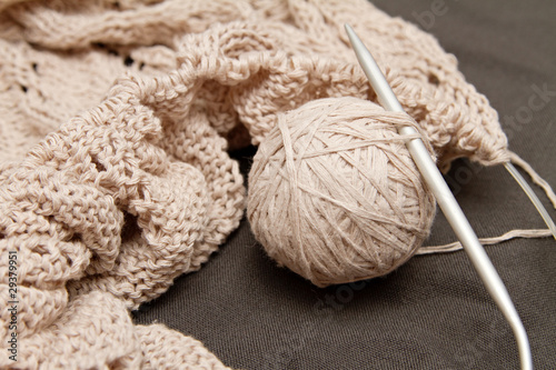 a beige knitted shawl with round needles