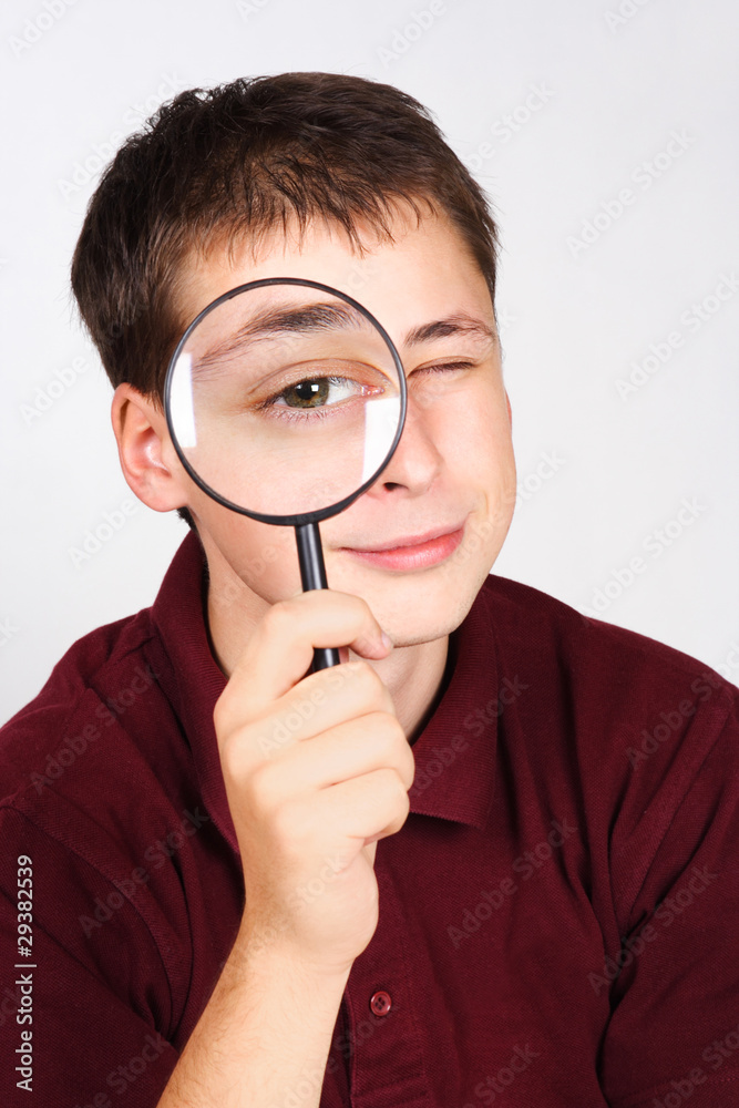 young man holding magnifier and looking through it, big eye young man holding magnifier and looking through it, big eye