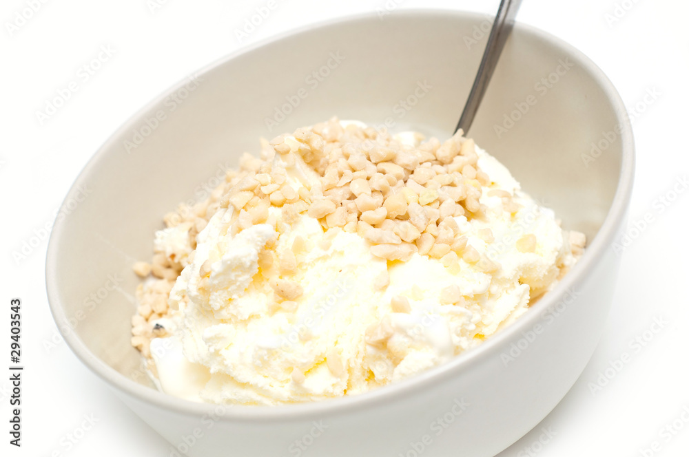 icecream with nuts tossed on top, against white background icecream with nuts tossed on top, against white background