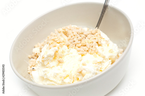 icecream with nuts tossed on top, against white background