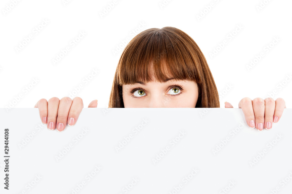 Pensive woman peeking over blank billboard Pensive woman peeking over blank billboard