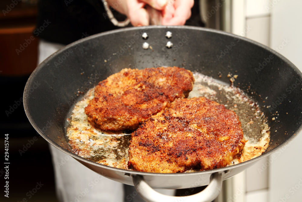 Paniertes Schnitzel in der Pfanne Paniertes Schnitzel in der Pfanne