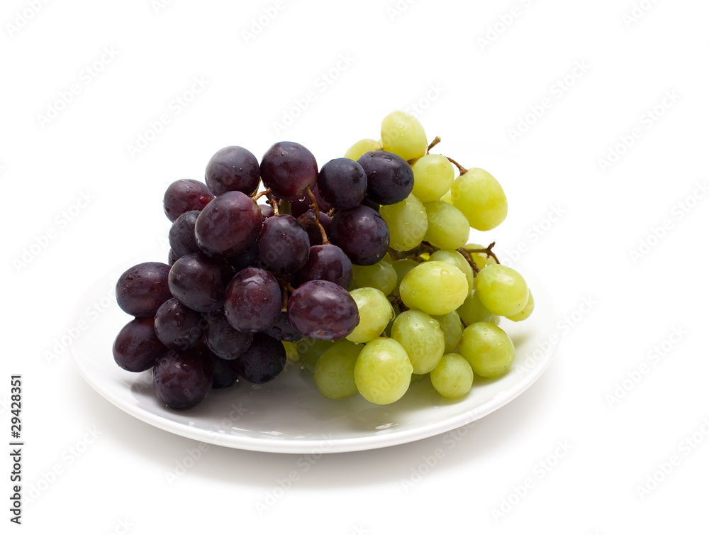 two bunches of grapes on a plate