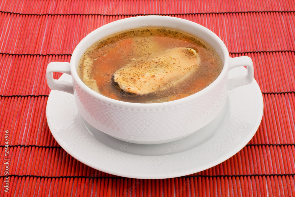 Soup with salmon and hot peppers on a red background Soup with salmon and hot peppers on a red background