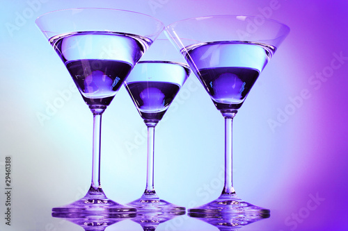 Three martini glasses on purple background