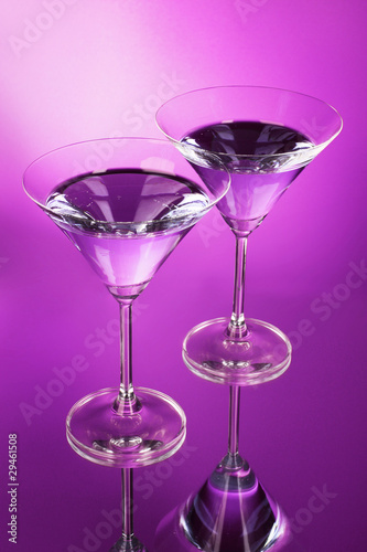 Two martini glasses on purple background
