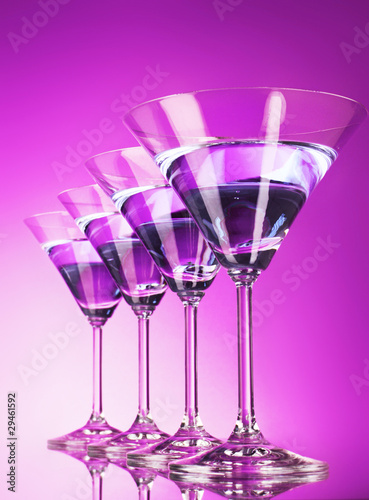 Four martini glasses on purple background