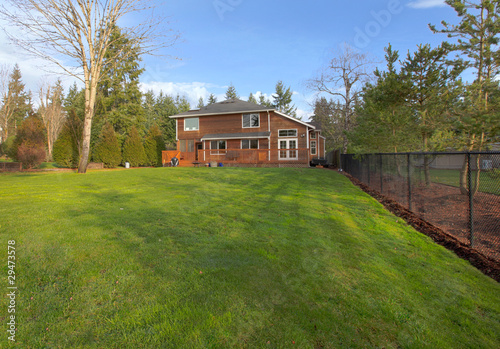 Green grass and large yard with cedar wood house