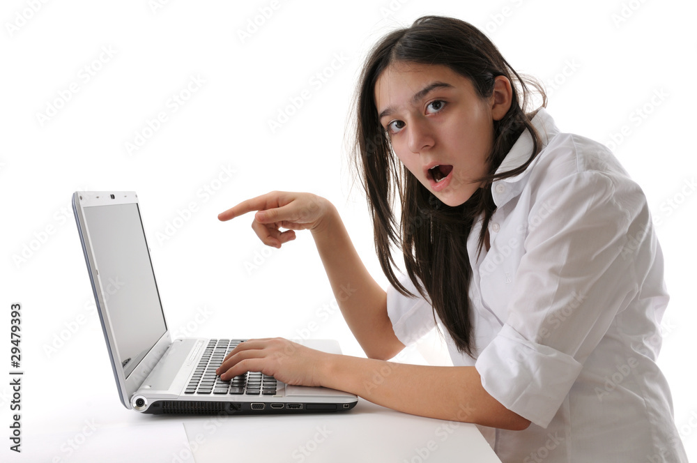 Teen girl pointing out laptop isolated on white background.