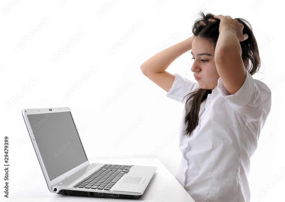 Frustrated teen girl working on computer isolated. Frustrated teen girl working on computer isolated.