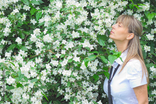 outdoor portrait of young woman smelling jasmine flowers