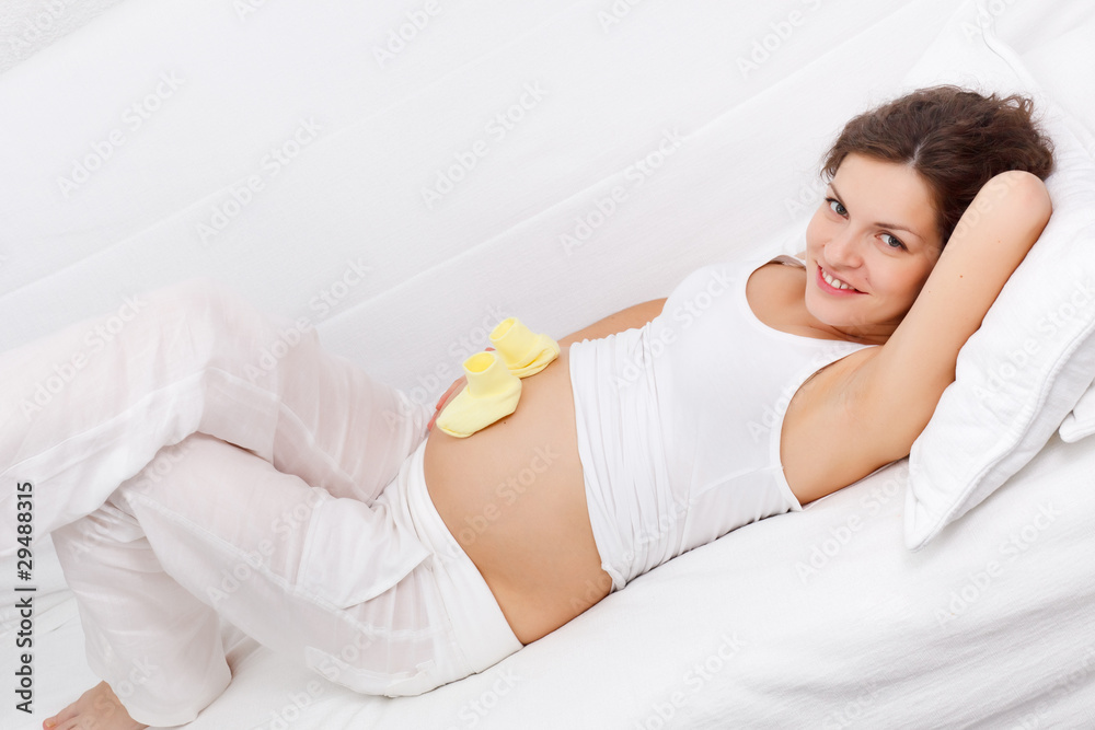 Young pregnant woman relaxing on sofa Young pregnant woman relaxing on sofa