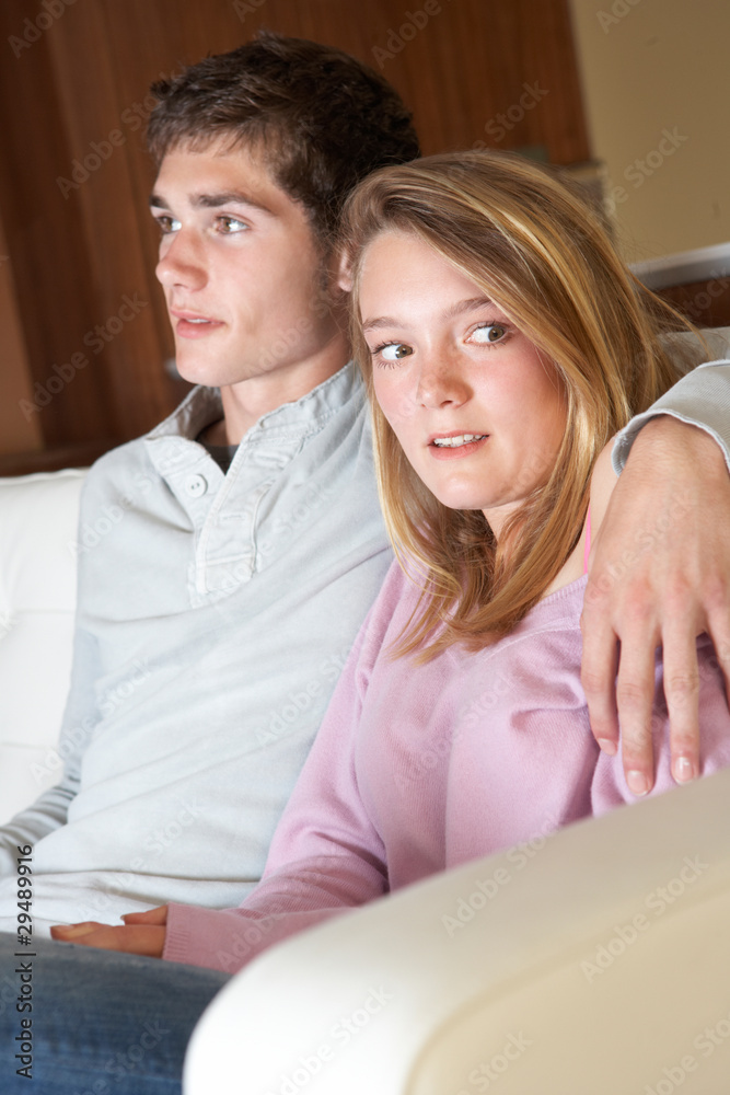 Nervous Looking Teenage Girl Sitting On Sofa At Home With Boyfri Nervous Looking Teenage Girl Sitting On Sofa At Home With Boyfri