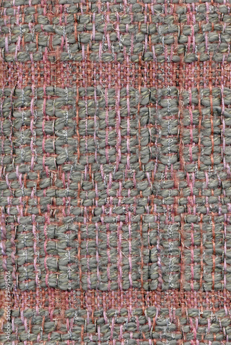 Close up detail of handwoven, patterned fabric in pink and gray