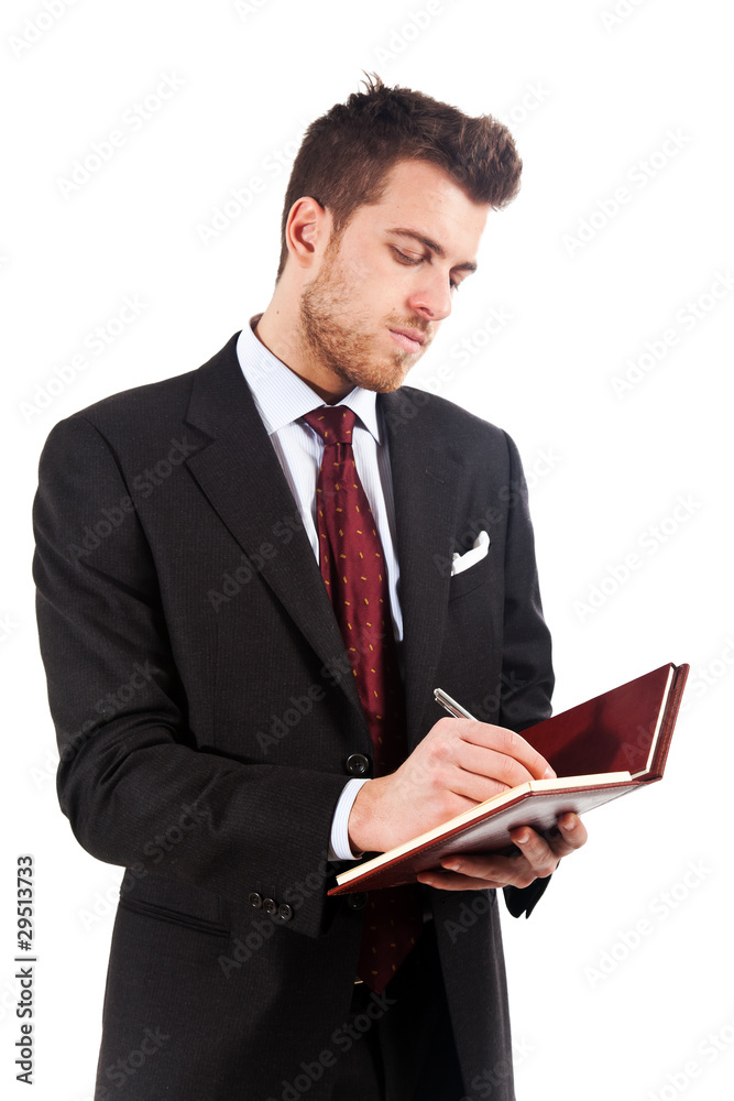 Businessman in black suit writing on agenda isolated on white Businessman in black suit writing on agenda isolated on white