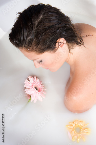 woman relaxing in milk bath with flowers