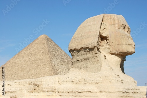 Statue of Sphinx with Giza Pyramid in the background, Egypt