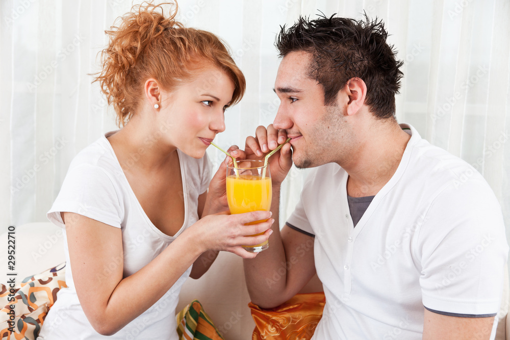 handsome boy and a beauty, young girl drinking orange juice handsome boy and a beauty, young girl drinking orange juice