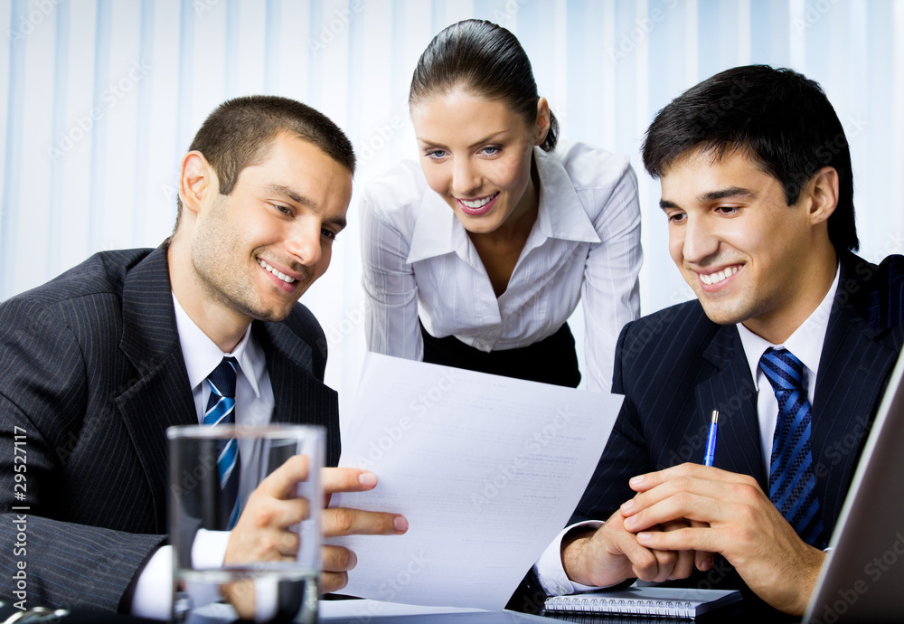 Three businesspeople working with document at office Three businesspeople working with document at office