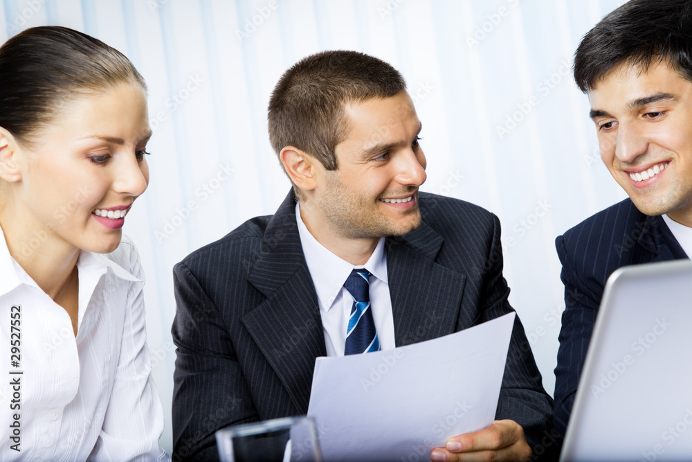 Three businesspeople working with document at office Three businesspeople working with document at office