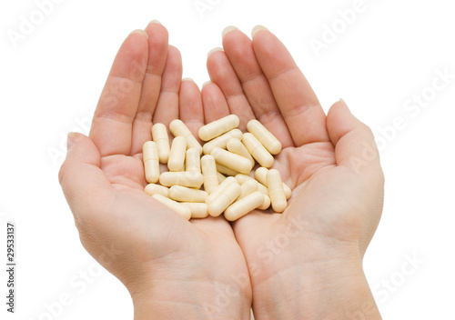 Hand with a pill on white background