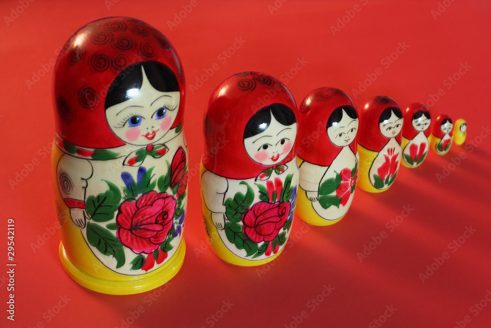 A set of Russian dolls on the red background.