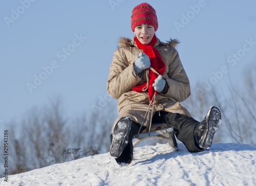 Canvastavla Teen girl sledding from a hill