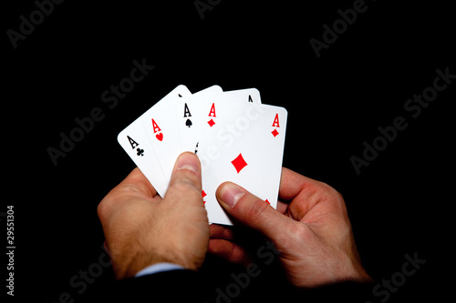 Four aces in hands isolated on black background