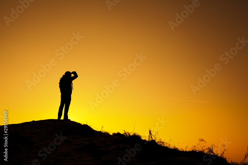 Mężczyzna obserwujący zachód słońca na szczycie góry
