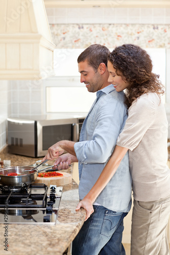 Woman hugging her husband while he is cooking