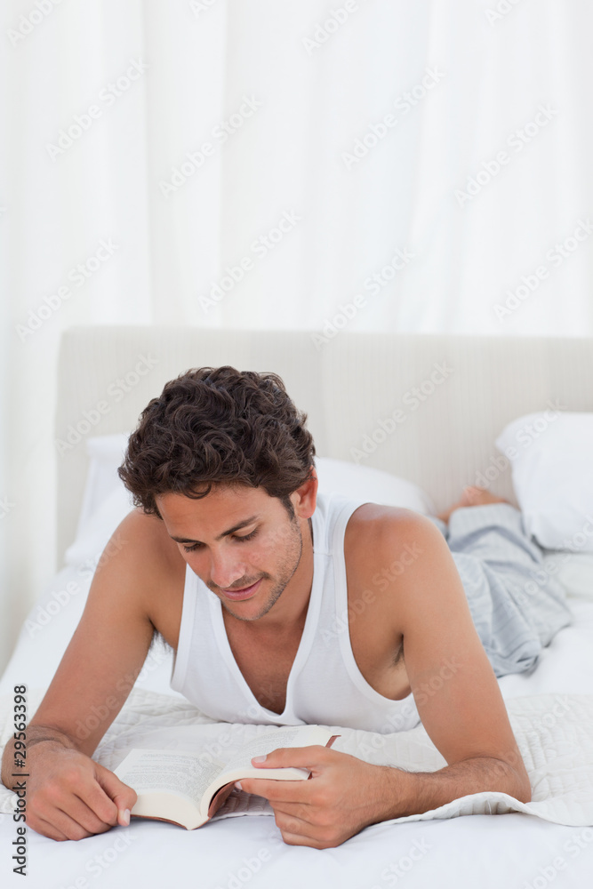 Man reading a book on his bed Man reading a book on his bed