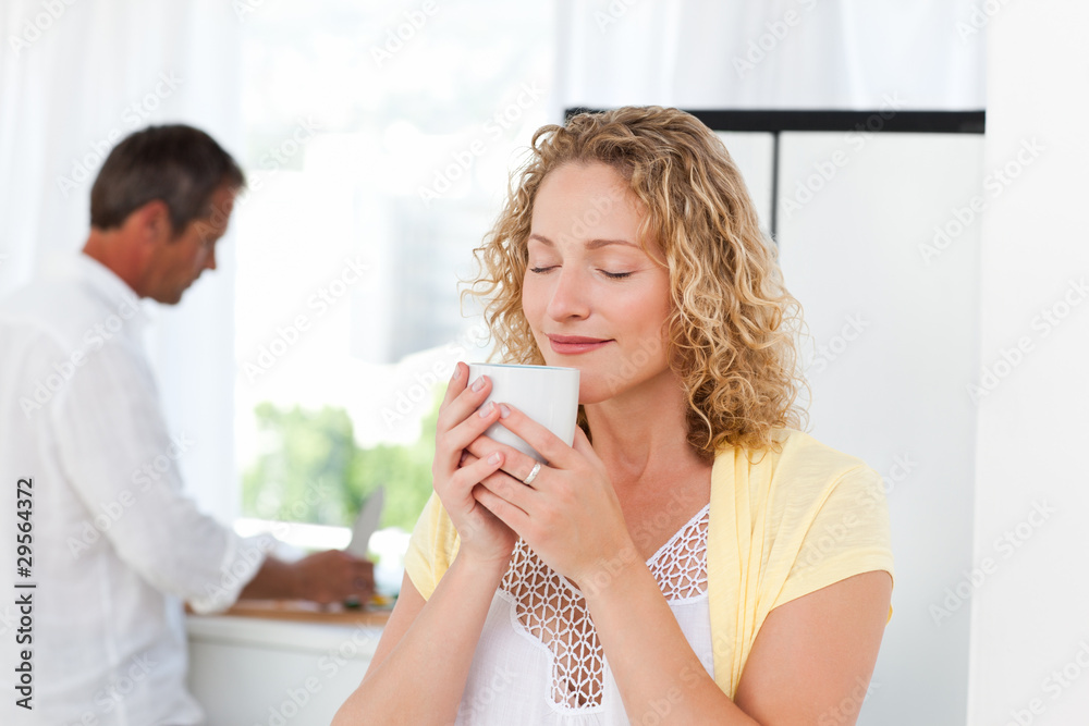Pretty woman drinking tea in her kitchen