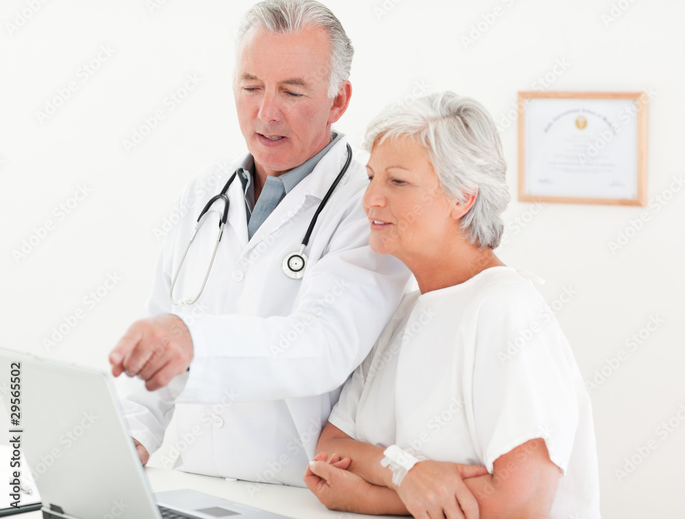 Doctor and his patient looking at the laptop Doctor and his patient looking at the laptop